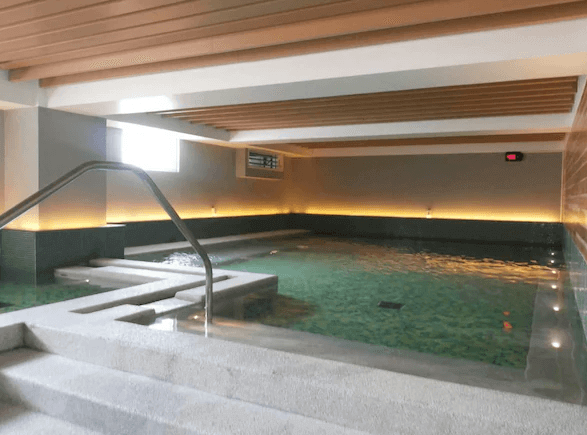 【宜蘭溫泉飯店】捷絲旅宜蘭礁溪館的一個室內溫泉池區，採用了現代化的設計，池水清澈，牆壁和天花板採用了簡約的線條設計，提供了一個放鬆的泡湯環境。光線柔和，增添了舒適的沐浴體驗。