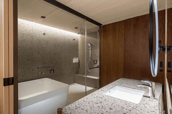 【花蓮市海景住宿】花蓮潔西艾美渡假酒店的浴室內部空間寬敞，以淺色系石材打造，搭配玻璃淋浴間與獨立浴缸，設計簡潔而高雅，提供舒適的沐浴空間。