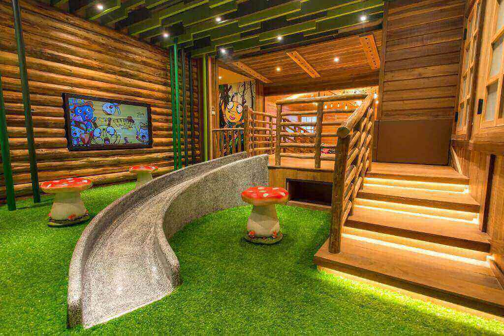 Colorful and playful children's indoor play area with cartoon themes and wooden cabin design