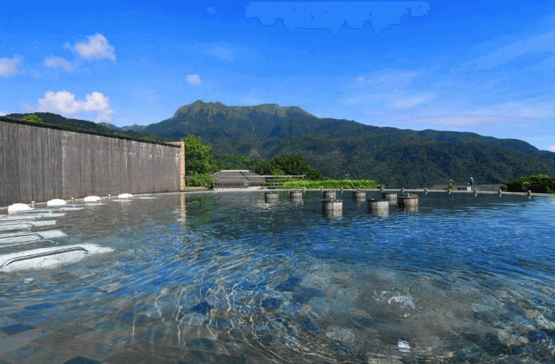 "台北親子飯店"【陽明山親子住宿】陽明山天籟渡假酒店的露天無邊際溫泉池，池水清澈，池邊設有座椅供旅客放鬆。遠方可以欣賞到壯麗的山景和藍天白雲，周圍環境清幽，適合放鬆身心，享受大自然的美景。