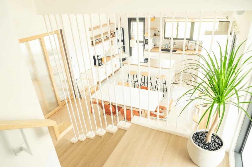 【美濃住宿】No.1899 人文旅宿的開放式廚房和餐廳區域，配有大型木製餐桌和高腳凳。廚房設備齊全，白色的櫥櫃和牆面使空間顯得寬敞明亮，整體設計風格簡潔且實用。