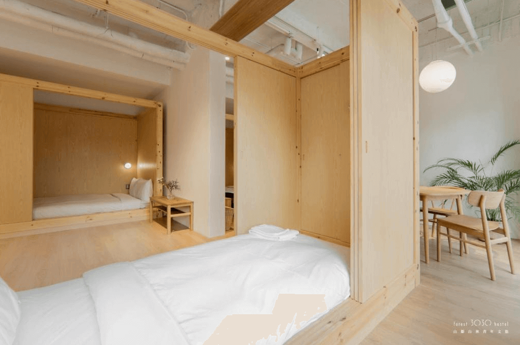 【玉里住宿】山鄰山林青年文旅的日式風格客房，木質隔間內設有床鋪和小桌子，營造出寧靜且私密的休息空間，適合追求安靜環境的旅客。