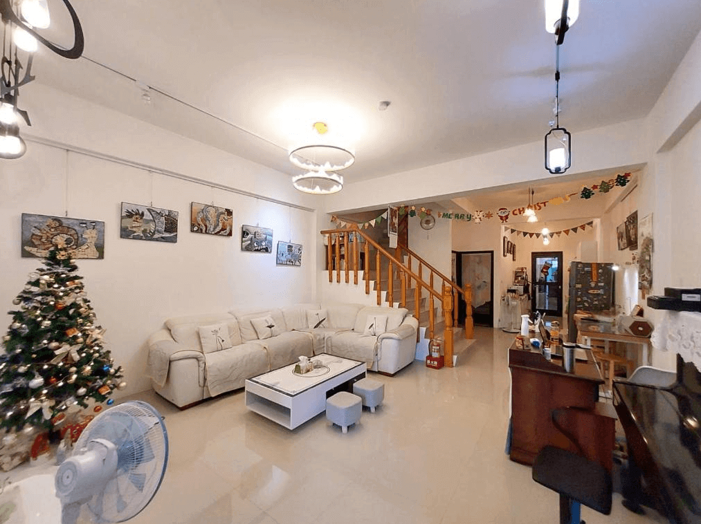 【玉里住宿】"玉里住宿精選示意圖"“赤柯山住宿”時雨民宿的公共休息區，有一張白色沙發和多張裝飾畫，牆上掛著聖誕裝飾，右側有一個小吧檯和鋼琴，營造出溫馨節慶的氛圍。