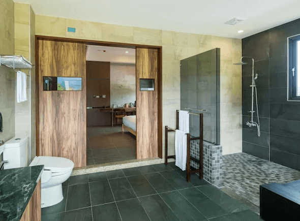 松邑莊園的浴室，內部寬敞，設有獨立淋浴間、洗手台和馬桶。浴室使用高品質的建材，設計簡潔大方，門通向臥室，整體設計風格統一。