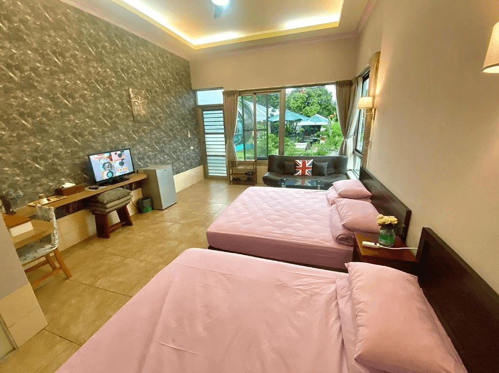 【美濃住宿】美濃涵園民宿房間，房內配有兩張雙人床，牆面採用大理石紋理設計，並配有電視和書桌。房間窗戶外可以看到庭院的景色，提供舒適的休息空間。