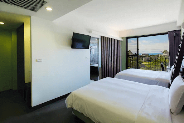 現代簡約風格的雙床房，設有兩張大床和一台掛壁式電視。房間內有大窗戶提供自然光，並可欣賞到室外景色，房內設施齊全，提供舒適的住宿體驗