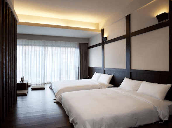 寬敞的雙床房，設有兩張大床和現代化的裝潢。房間內有大型窗戶，提供充足的自然光，並配有舒適的家具，營造出放鬆的住宿環境