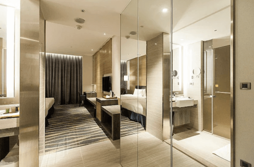 城市商旅高雄真愛館的客房內部，房間設計現代簡約，配有大面積鏡子，使空間感更加寬敞。房間內設有兩張單人床，並且提供書桌和其他基本設施，讓賓客享受舒適便捷的住宿體驗