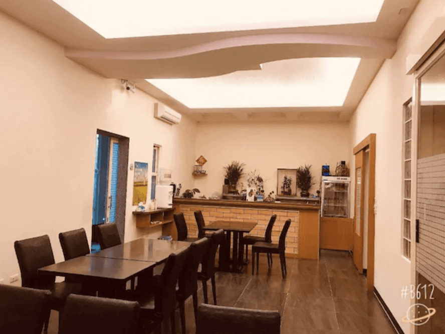 【池上民宿】玟均民宿的用餐區域，設有多張餐桌和椅子，適合團體和家庭聚餐。空間寬敞明亮，裝潢簡約大方，牆上裝飾有綠植和裝飾畫，營造出舒適的用餐氛圍