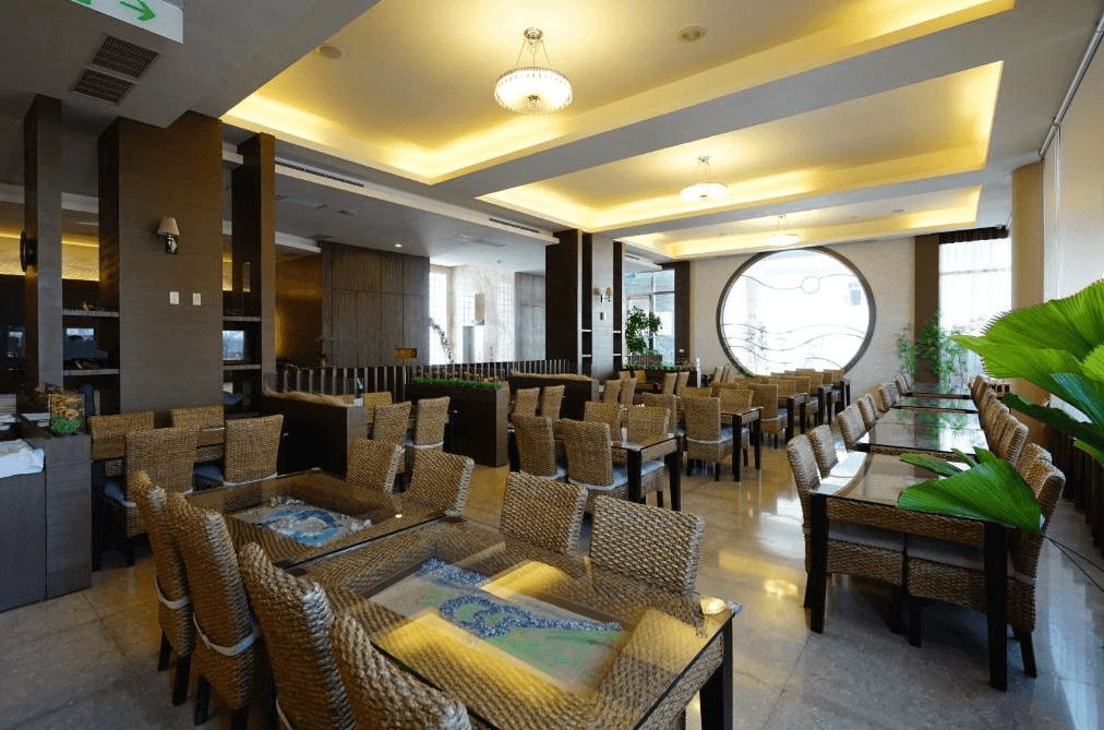 澎湖海悅飯店的餐廳區域，擺放著許多編織椅和玻璃桌，裝飾風格自然雅致，餐廳空間寬敞明亮，營造出一個舒適愉快的用餐環境。