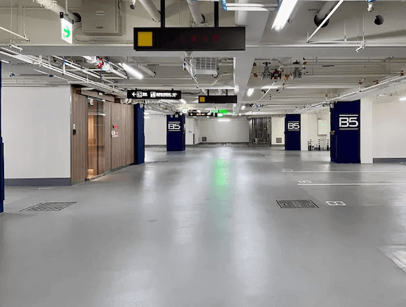見潭璞旅的地下停車場的照片，場地寬敞，有多個停車位和清晰的標誌，牆上有一些指示牌，地面乾淨整潔。