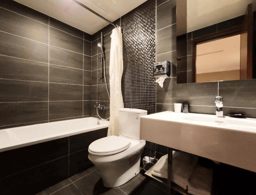 享住旅店浴室的照片，浴室內有一個浴缸，牆壁和地板採用深色瓷磚裝飾。洗手台簡約且功能齊全，整個空間乾淨且現代感十足。