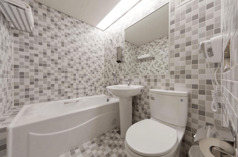 華帥海景飯店浴室的照片，浴室內配有浴缸，牆面和地板採用了灰白色調的馬賽克瓷磚裝飾，浴室乾淨整潔，設計簡單實用。