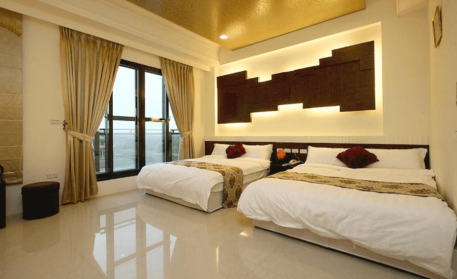 “頭城住宿”蘭博會館的雙床房，房內有兩張大床，背後牆面設計具有現代感，搭配隱藏式燈光，增添了房間的溫暖氛圍。房間內使用了金色和棕色的色調，並配有大窗戶，可以欣賞到外部景色，房間地板是光亮的大理石材質。