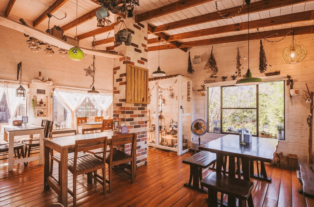 【南庄民宿】南庄橄欖樹咖啡民宿的餐廳區域，空間充滿鄉村風情，木製家具和天花板上的橫樑設計呼應整體風格。室內裝飾有乾燥花和工藝品，增添了家的溫馨感，讓人感受到親切的用餐環境。