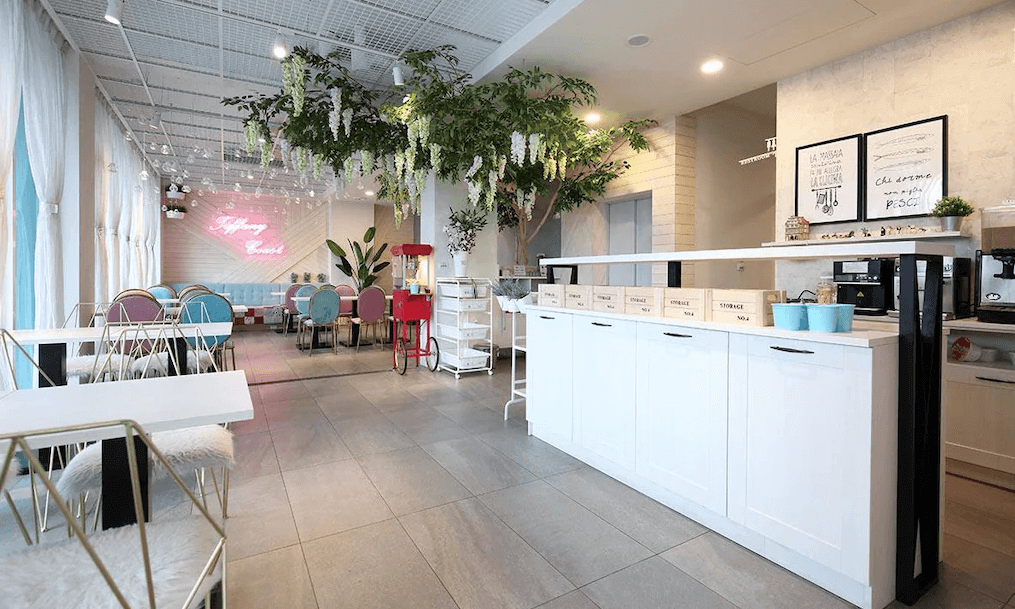 微藍海岸旅宿的用餐區色彩繽紛，設有多樣的座椅選擇，並以綠色植物點綴，營造出清新愉悅的氣氛。牆上的霓虹燈字樣和可愛的擺設，讓空間顯得活力十足，非常適合放鬆享用餐點。