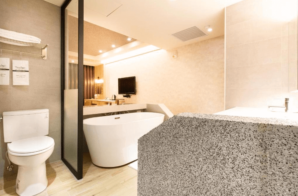 【新營汽車旅館】丹尼爾汽車旅館寬敞明亮的浴室，配有獨立造型浴缸及現代化設施，開放式設計與房間相連，提升空間的整體感與舒適度。