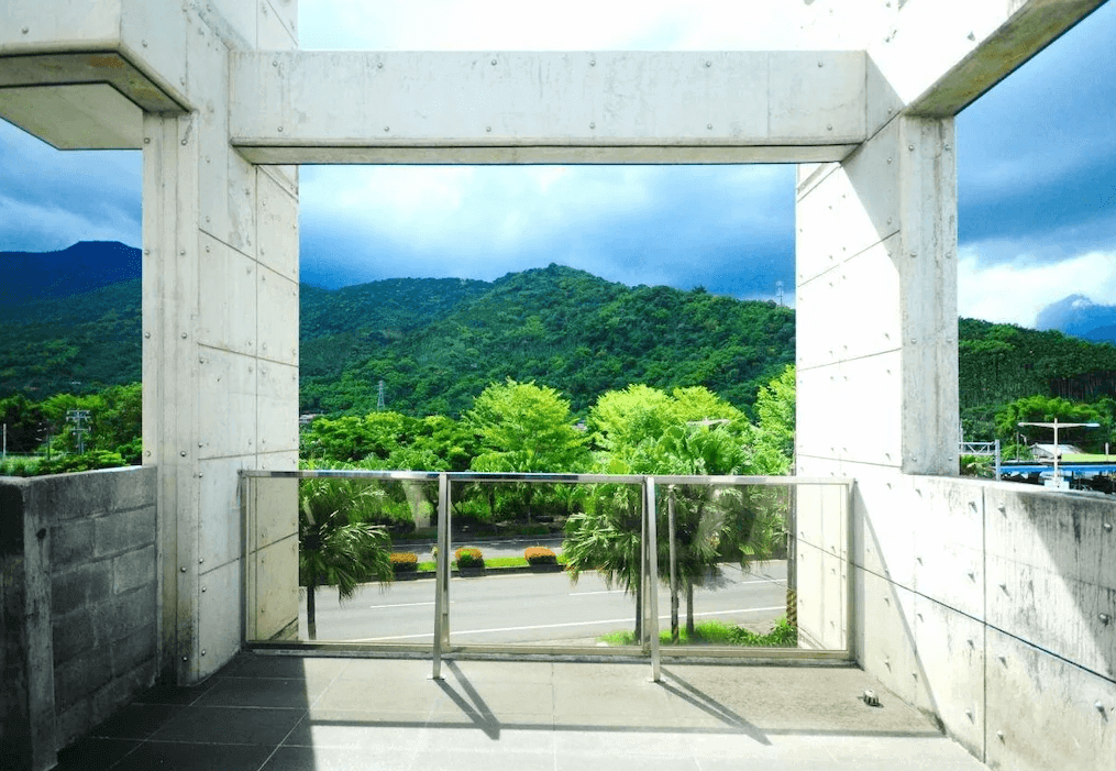 伊之旅宿的露台設計現代感十足，俯瞰窗外青山與綠樹的景色，陽光灑落其上，讓人感到放鬆愉悅，適合觀景休憩。
