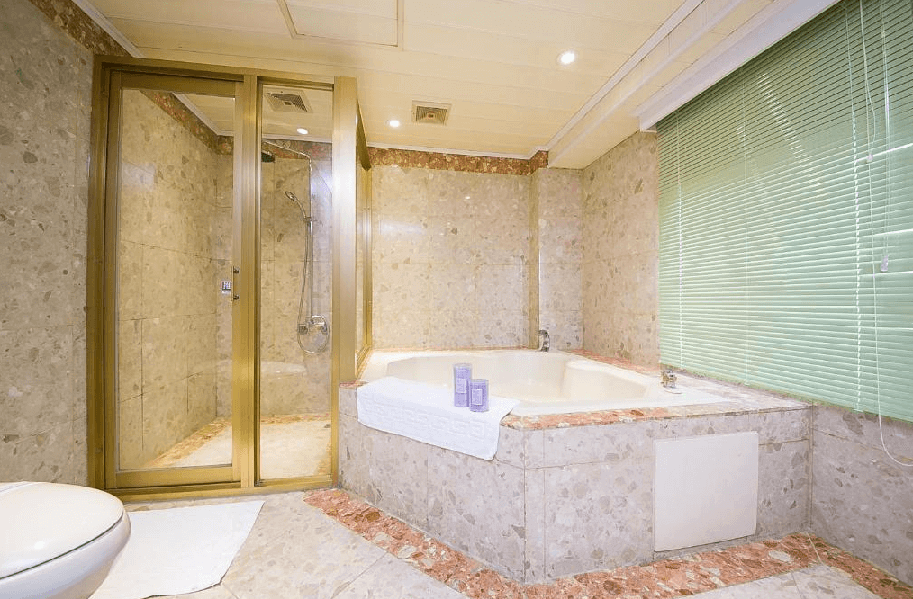 【新營汽車旅館】歐堡商務汽車旅館豪華寬敞的浴室空間，配有大理石裝飾的大型浴缸和獨立淋浴間，提供舒適放鬆的使用體驗。