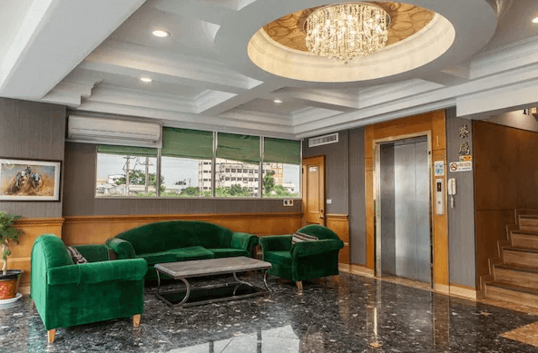 【新營汽車旅館】歐堡商務汽車旅館典雅大方的接待大廳，綠色沙發搭配大理石地板，中央吊燈增添高級感，提供溫馨舒適的迎賓環境。