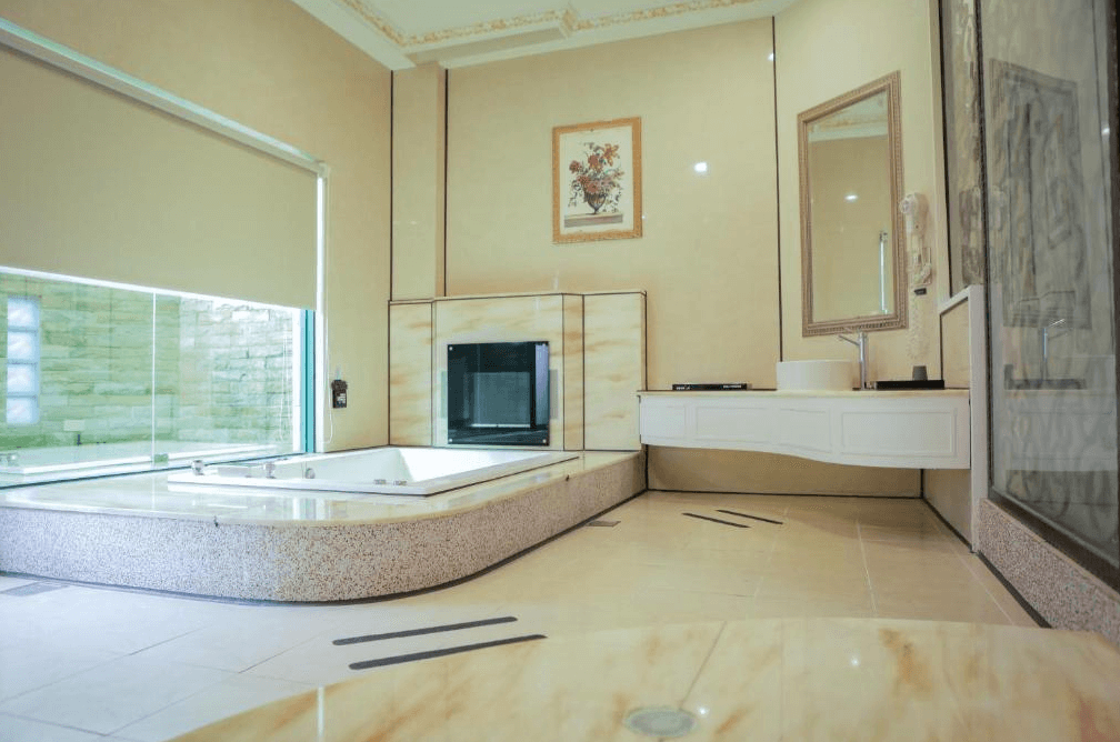 【新營汽車旅館】歐悅連鎖精品汽車旅館-新營館的豪華寬敞浴室設計，配有大型按摩浴缸和落地窗，採光良好，提供現代化衛浴設施和高雅的裝飾細節。