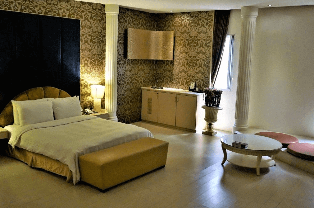 【新營汽車旅館】禾楓水舍汽車旅館華麗典雅的客房，牆面以古典花紋裝飾，搭配高柱和圓形茶几，展現出獨特的歐式風格。