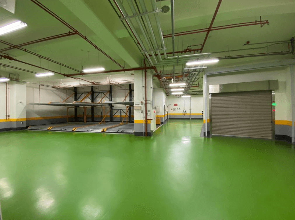 賓利酒店酒店的地下停車場，地面塗有鮮綠色防滑漆，內部停車位清晰標示，配有機械式升降停車設備，空間整潔且明亮，提供便捷的停車服務。