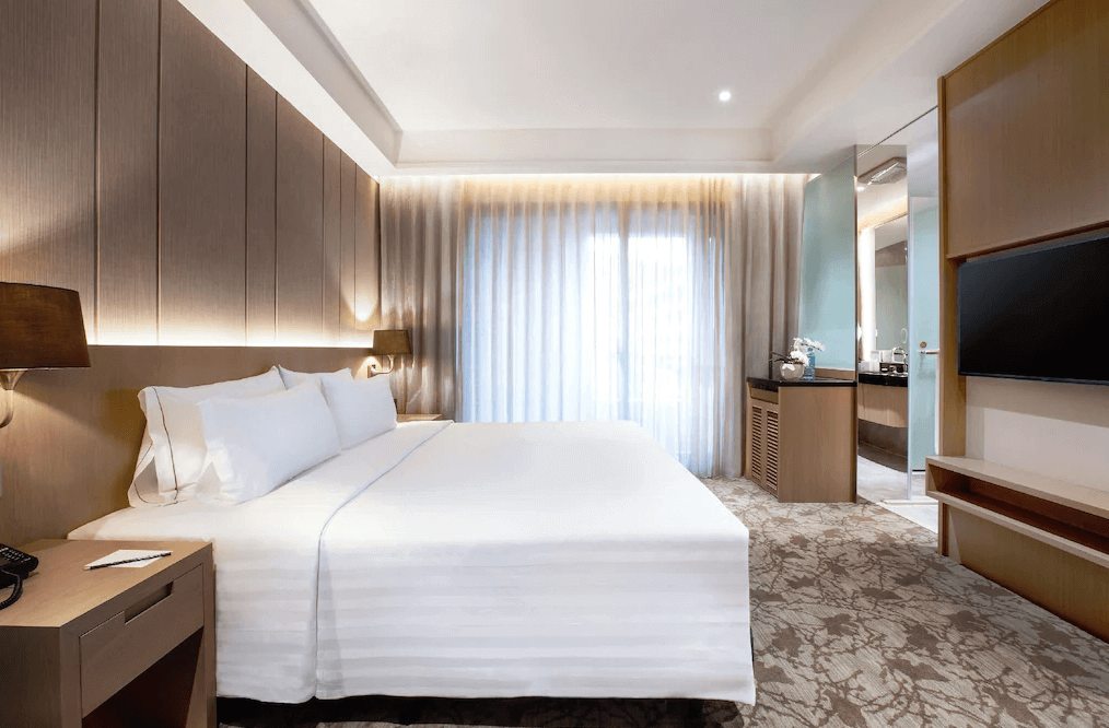 【礁溪住宿】中天溫泉渡假飯店的雙人房，床頭牆面採用木質元素，房內提供柔和燈光與現代化設施，浴室連接臥室，並配有高品質的衛浴用品。