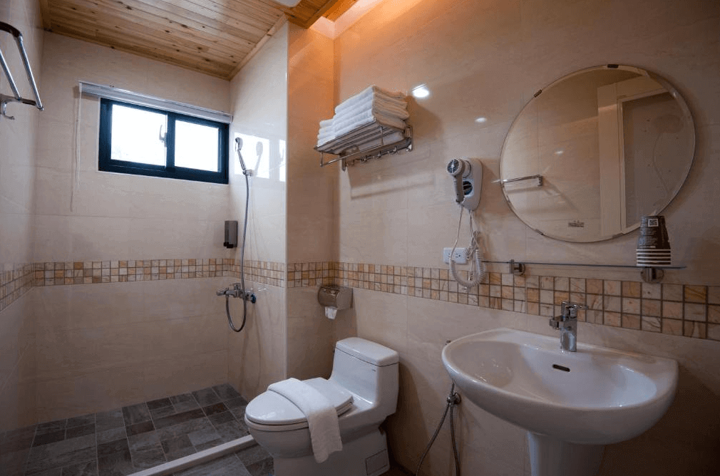 【溪頭住宿】心之境民宿的浴室設計簡潔，搭配明亮的燈光與木質天花板，乾濕分離的設計提供便利與清潔感，整體氛圍溫暖舒適。