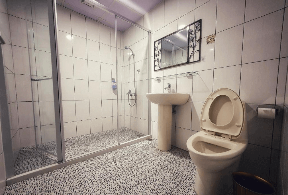 【水里住宿】樂水軒民宿的浴室採用白色磁磚設計，乾濕分離的淋浴空間，搭配簡潔的洗手台與馬桶，清潔整潔，實用性高。