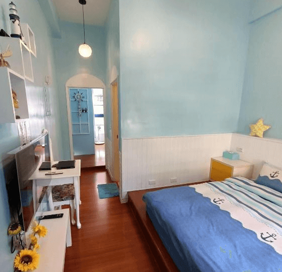 【水里住宿】水里河堤咖啡民宿的藍色主題的臥室，帶有一絲海洋風情，牆面配有簡潔的裝飾架，擺放著海洋相關的擺設，整體空間清新明亮，非常適合情侶或家庭旅遊。