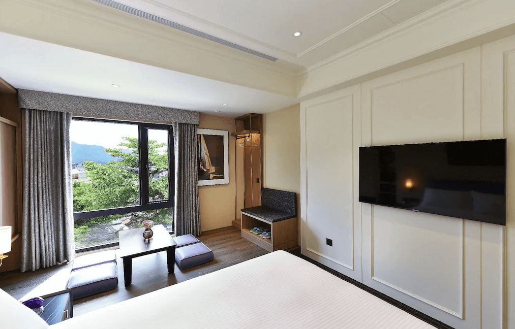 【水里住宿】水里福容徠旅的房內設有大片落地窗，自然光線充足，提供簡約日式座椅區與衣櫥空間，室內設計以簡潔線條為主，舒適又現代。