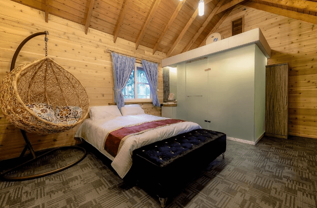 【溪頭住宿】溪頭杉溪鹿溜滑梯小木屋的內部空間充滿童趣，設有溫暖的木質床與窗戶，吊椅設計優雅且實用，非常適合情侶或小家庭入住，享受自然與舒適的結合。