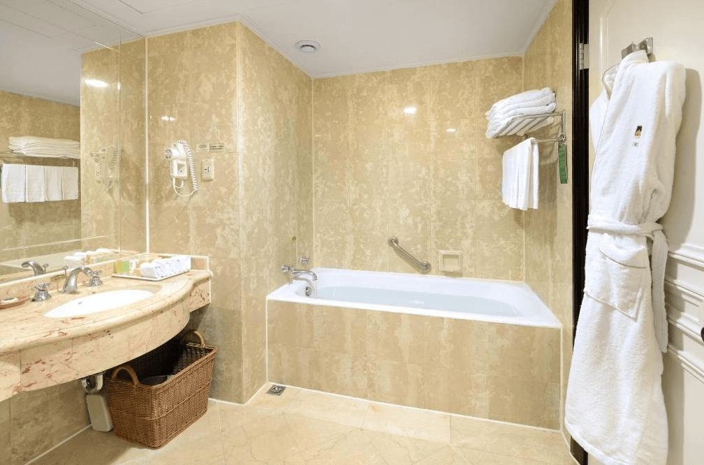 【溪頭住宿】溪頭米堤大飯店寬敞明亮的浴室，配有浴缸和洗手台，牆面以大理石材質裝飾，增添典雅氛圍。