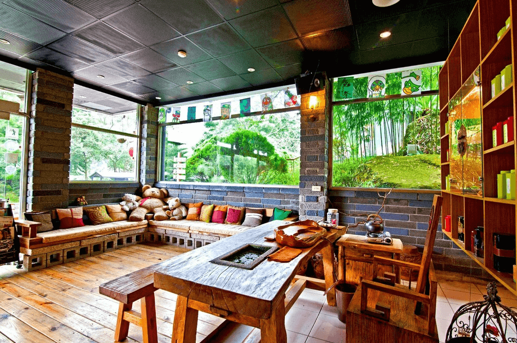 【溪頭住宿】溪頭聽濤園的公共休憩區空間寬敞，採用木質地板與自然素材的家具設計，窗外綠意盎然，適合旅客在此放鬆或聚會，搭配童趣裝飾，增添溫馨感。