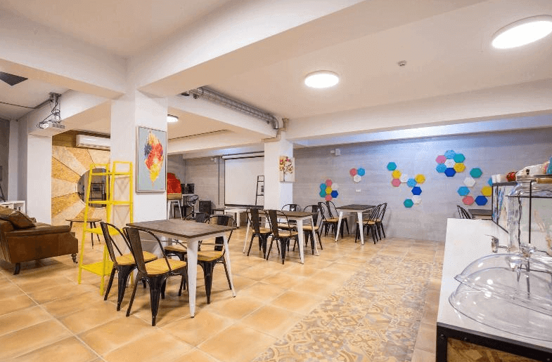 【溪頭住宿】漫步山嵐的公共用餐空間充滿活潑氛圍，牆面上裝飾著彩色幾何圖案，座椅和桌子的配置適合多人聚餐或小型活動，是旅客互動與放鬆的好地方。