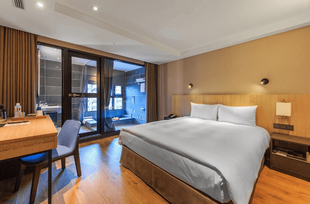 礁溪福朋喜來登酒店的雙人房，設計簡約大方，房內配有一張大床，木質地板增添自然感，落地玻璃窗通往一間帶有現代化設計的浴室，浴室內設有泡湯設施。