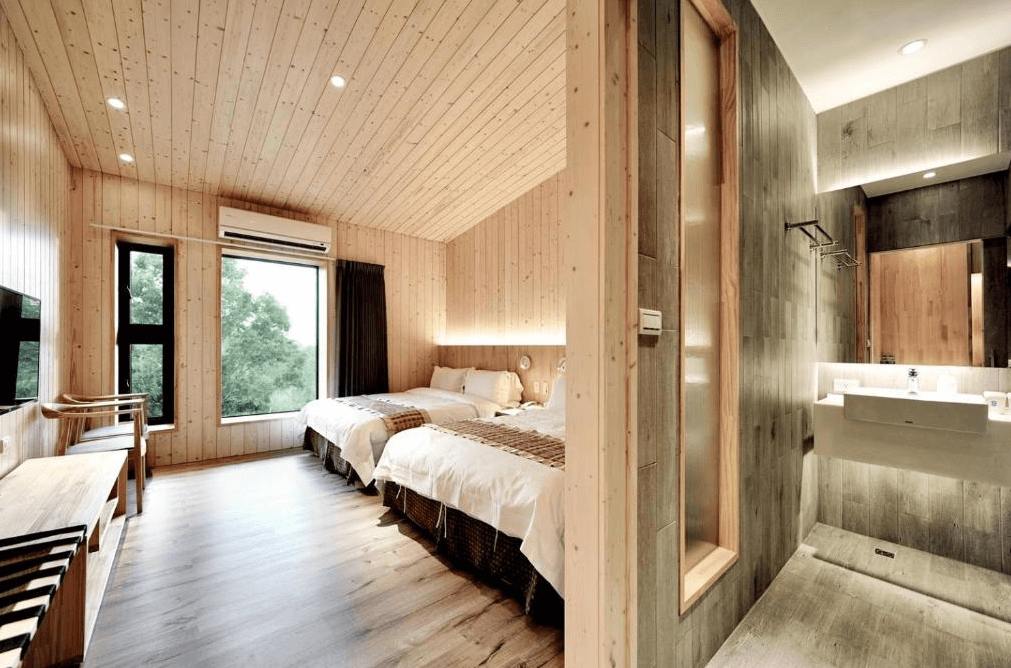 【通霄住宿】飛牛牧場的簡約北歐風格雙人房，滿滿的原木設計營造自然溫馨的氛圍。房間內有兩張單人床，大片窗戶可見外面的綠意景色，浴室乾濕分離設計，配色現代且質感十足。