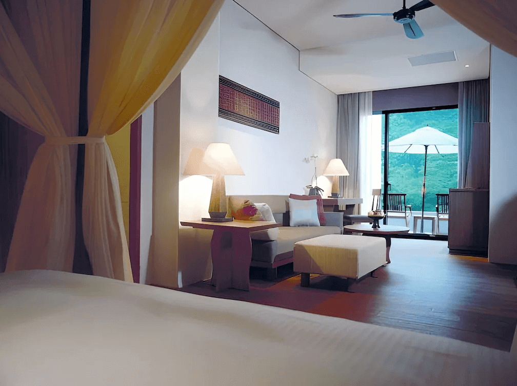 【烏來住宿】馥蘭朵烏來渡假酒店的套房內部設計現代時尚，客廳區域配有舒適沙發，推門即可通往帶有戶外家具的陽台，窗外可欣賞青山美景。