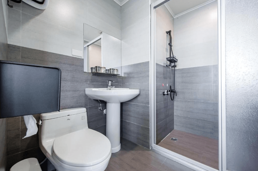 【日月潭住宿】H& 日月潭水漾的浴室設有獨立淋浴間及簡約設計的洗手台，搭配灰白色調的瓷磚牆面，呈現現代且乾淨的風格，符合旅客的使用需求。