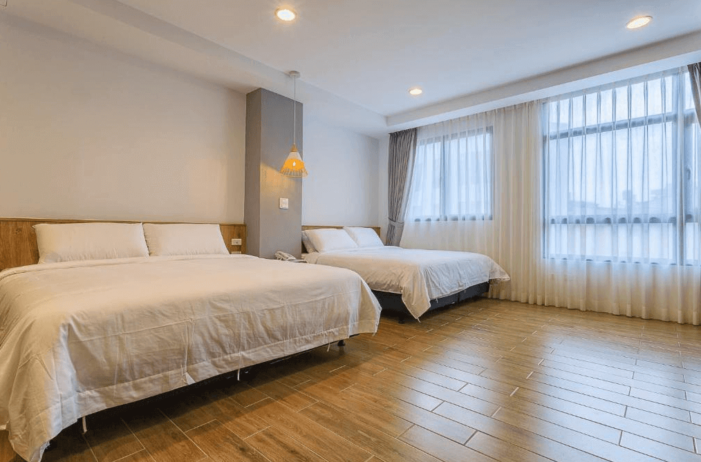 【日月潭住宿】嘎巴暮暮的房間寬敞明亮，設有兩張大床，適合家庭或多人入住。簡約的白色牆面搭配溫暖的木質地板，營造出舒適溫馨的氛圍。大片窗戶讓自然光線充足，搭配輕盈的窗紗，增添柔和感。