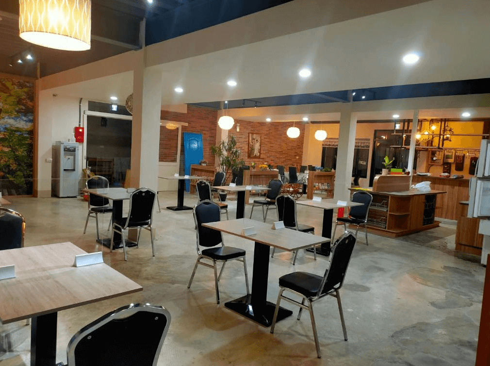 【司馬庫斯住宿】崗好山莊的餐廳空間，內部設有多張現代化桌椅，裝飾以木質與磚牆結合，燈光柔和，環境明亮且整潔，非常適合用餐或聚會使用。