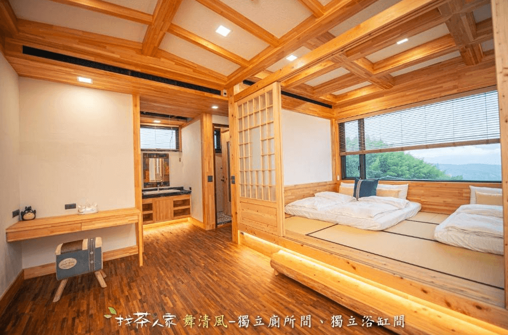 【阿里山住宿】找茶人家-檜木民宿的客房採用全檜木裝潢，帶有濃厚的自然氣息。榻榻米床鋪提供舒適的住宿體驗，大面積窗戶引入自然光線與山景，整體設計優雅且寧靜。