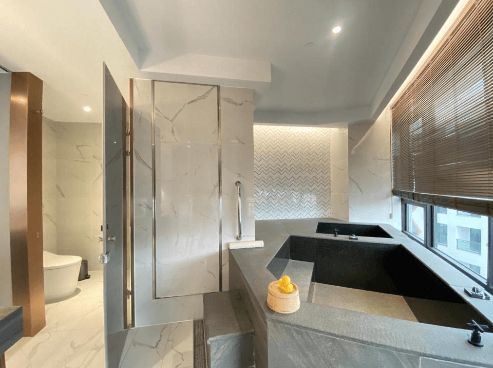 【日月潭住宿】日月潭力麗溫德姆溫泉酒店浴室內的設計高雅，配備雙人浸泡浴缸與大理石紋牆面，營造高級的放鬆空間。窗外景色為山林與湖泊，令人倍感放鬆。