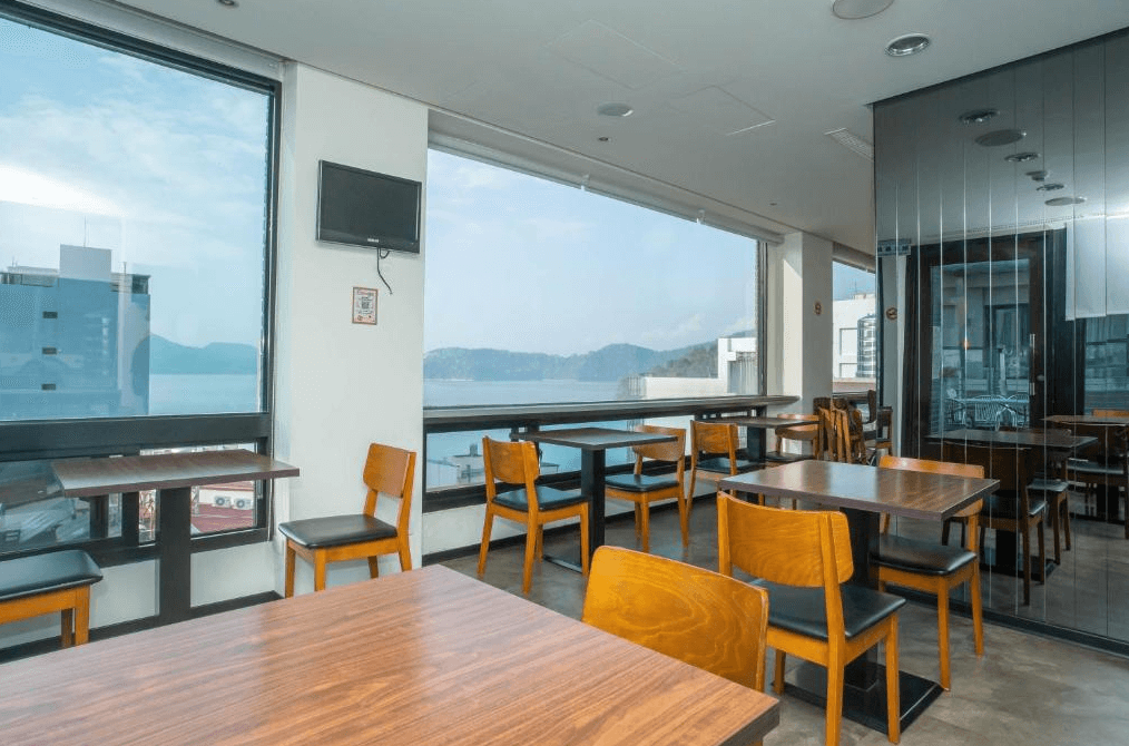 【日月潭住宿】日月潭天月水色民宿的餐廳空間設有大片落地窗，可欣賞湖泊景色，搭配木質桌椅設計，簡約而舒適。自然光線充足，營造明亮的用餐環境，適合放鬆享受早餐或下午茶時光。