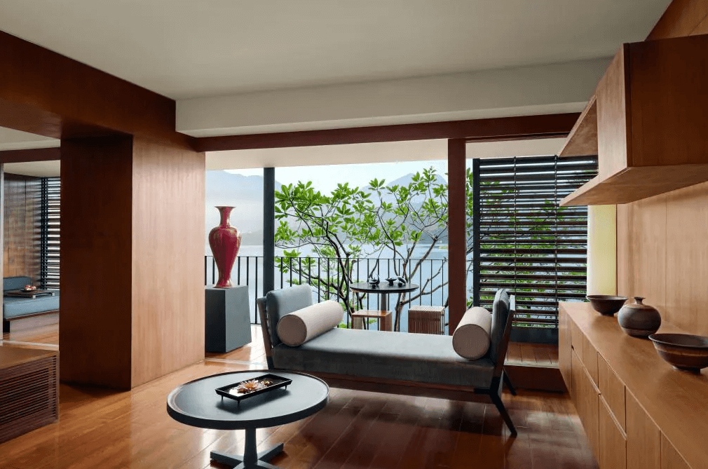 【日月潭住宿】日月潭涵碧樓酒店的沙發和陽台，陽光透過綠植灑入室內，空間開放且溫馨，營造高雅氛圍。