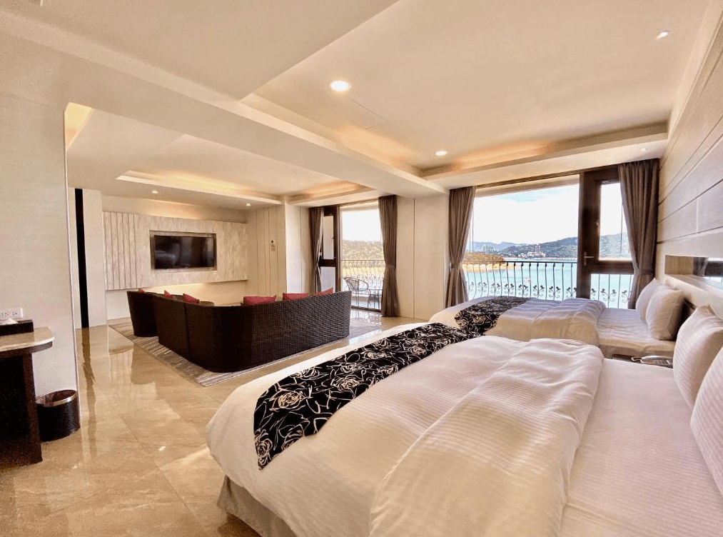 【日月潭住宿】明月湖品味湖畔旅店的豪華家庭房設計寬敞，配有兩張雙人床與獨立沙發區，適合家庭或小團體入住。大片落地窗與陽台提供湖景視野，讓住客享受愜意的自然景色與充足光線。