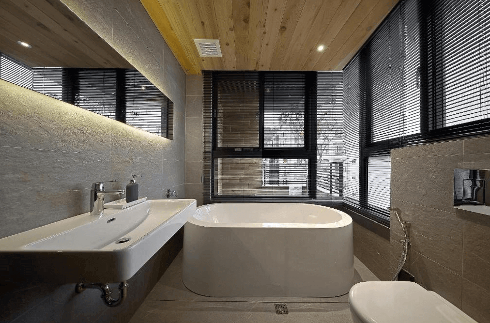 【日月潭住宿】桂月村的浴室設計注重現代化與舒適感，配備獨立式浴缸及淺色瓷磚牆面，搭配溫暖木質天花板。大面窗戶提供良好的採光，黑色百葉窗增加隱私，整體設計簡潔且高雅。