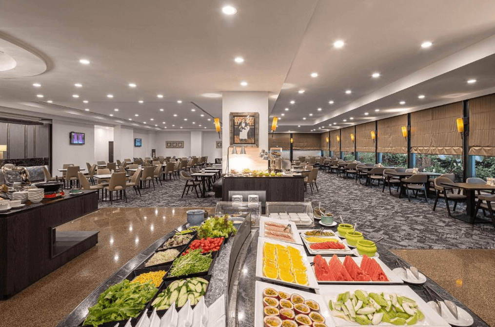 【新竹火車站住宿】煙波大飯店 新竹都會館寬敞的自助餐廳內設有多排餐桌與舒適座椅，並設有擺滿色彩繽紛的新鮮水果與沙拉的餐台。大窗戶提供明亮的自然光，營造出溫馨且舒適的用餐氛圍。