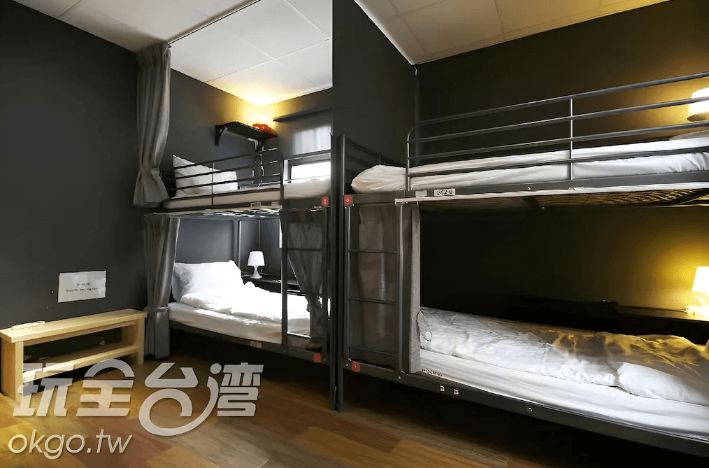 【日月潭住宿】玥湖背包客讚民宿的背包客房設計注重實用性，內設上下鋪床位，適合團體或個人旅遊住宿。深色系牆面搭配柔和燈光，營造出沉穩且舒適的睡眠環境，床位設有個人隱私窗簾，提供更貼心的住宿體驗。